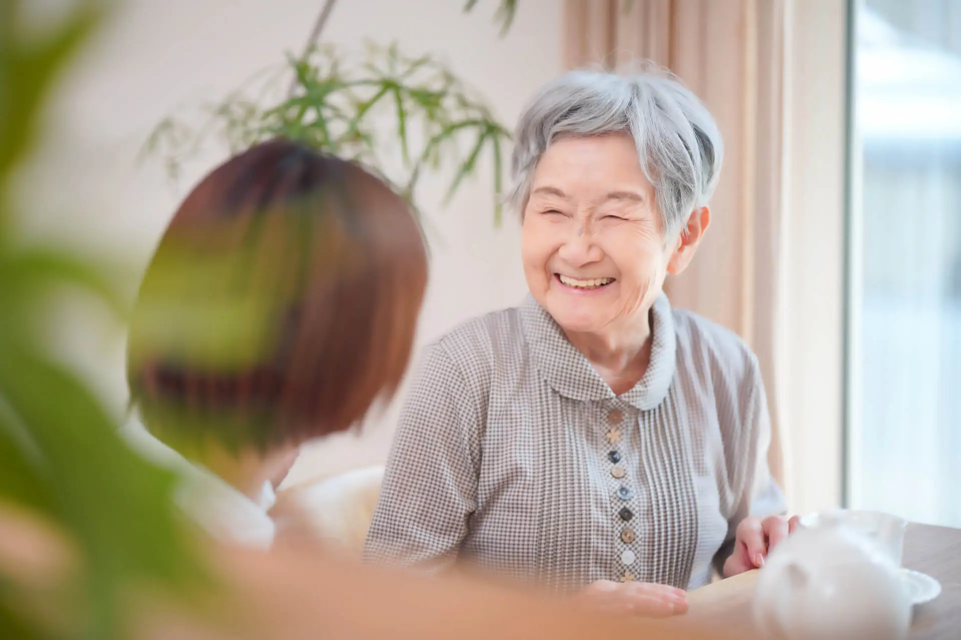 ベッドで看護師と会話をする高齢女性